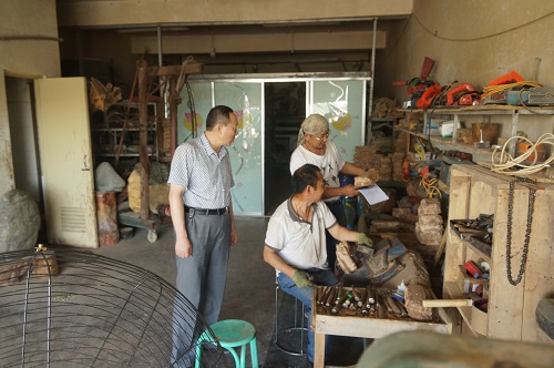 玛纳斯县残联副理事长陈德权在自然印象碧玉发展有限公司加工车间里了解残疾人张德荣的工作情况.JPG