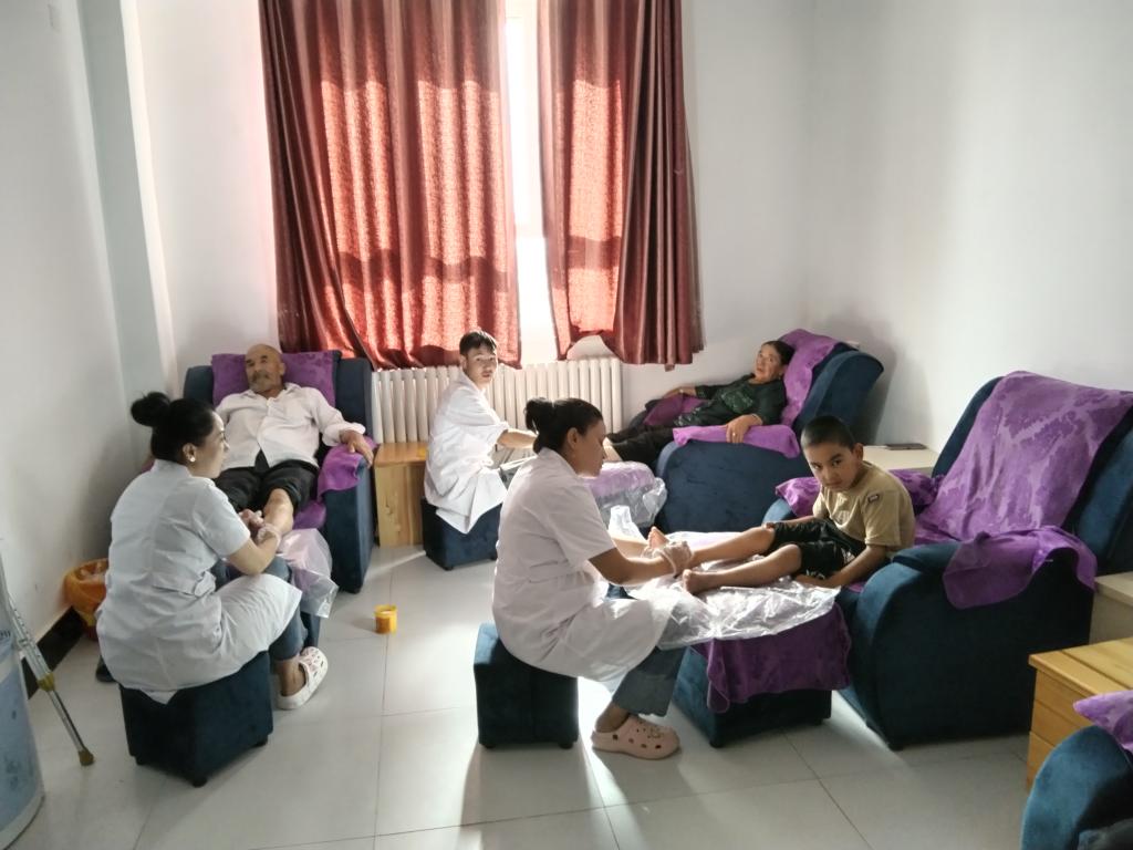 图为康复中心医务人员为残疾人做足疗