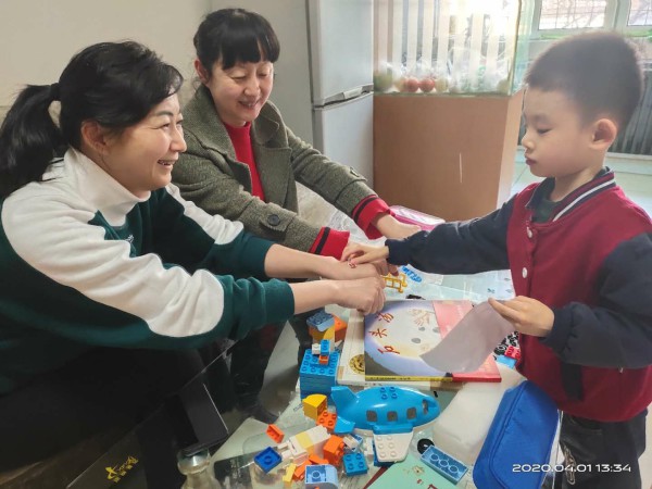 中心朱禾主任和新疆广播电视局团委书记原琦与孤独症儿童互动.jpg